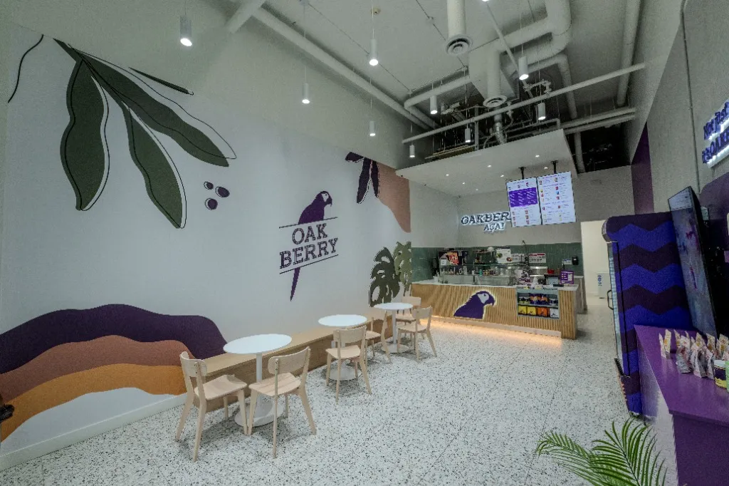 Open-plan interior with curved seating, round tables and a timber service counter — OAKBERRY AÇAÍ — SURREY, BC